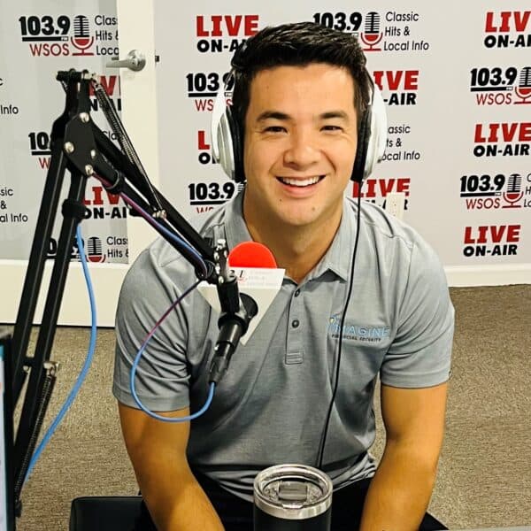 A smiling man seated at a broadcasting station, ready to engage with his audience on a radio show.