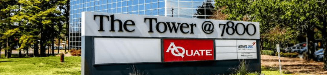 A signboard in front of a commercial building that reads 