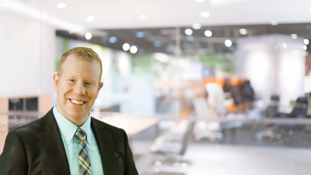 Confident businessman smiling in a modern office environment.