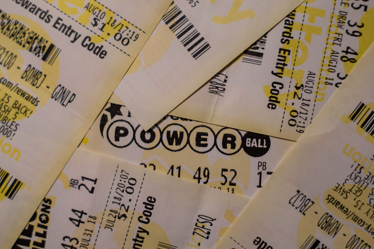 A collection of lottery tickets scattered about, with a prominent powerball ticket in the center.