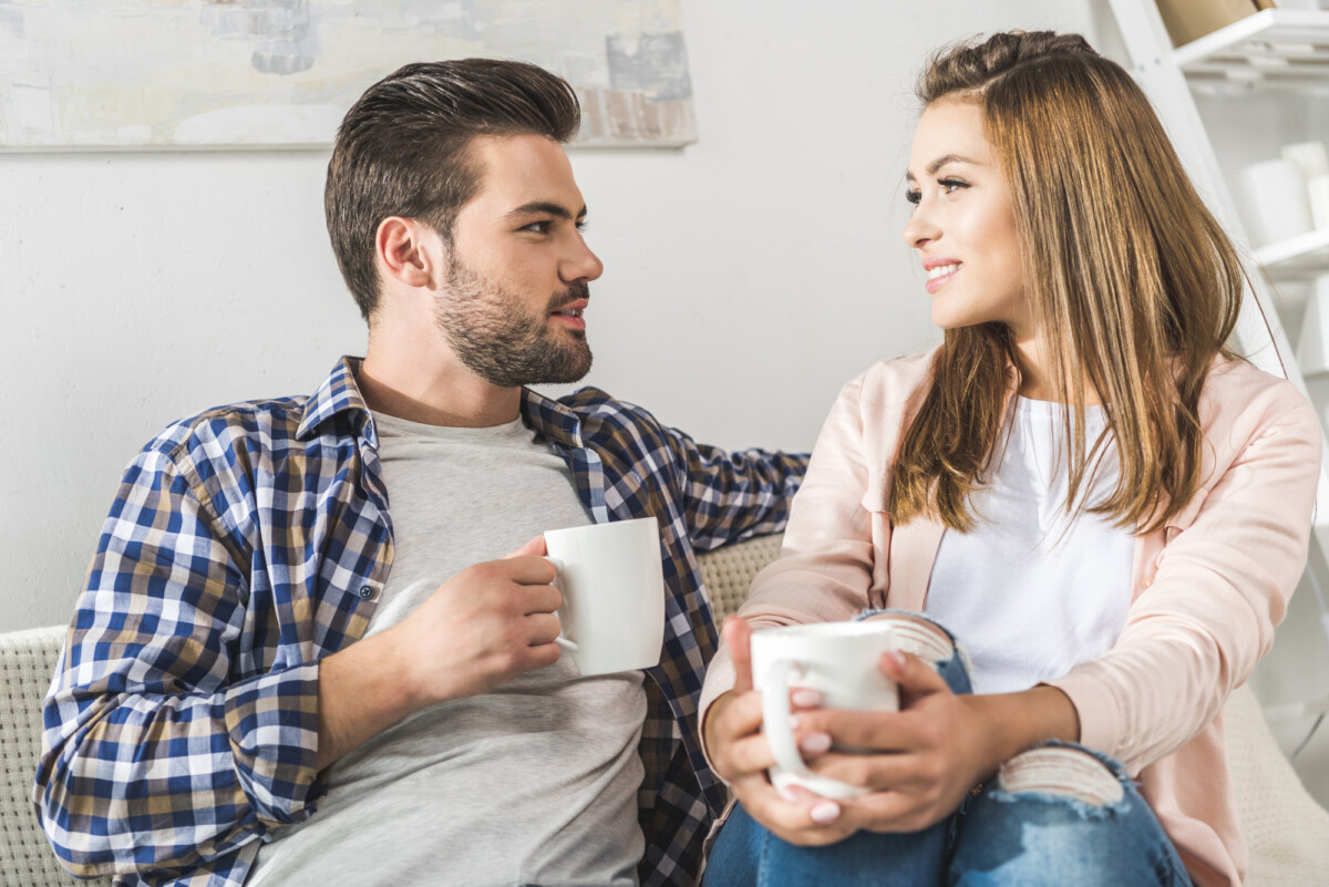 Cozy conversation over coffee - a couple enjoys a warm, relaxed chat at home.